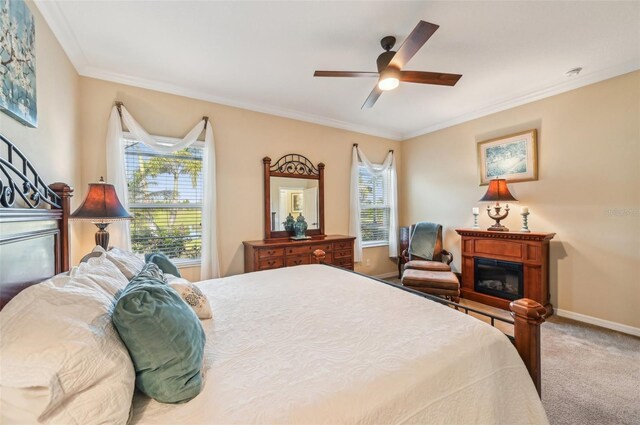 bedroom featuring carpet floors, crown molding, baseboards, and a ceiling fan