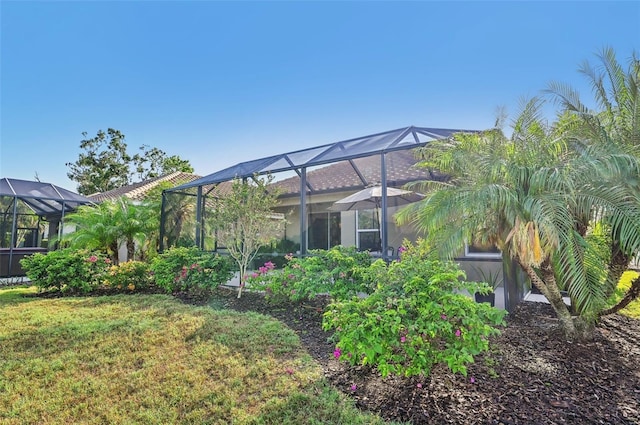 back of property featuring a lanai and a yard