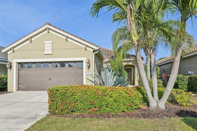 view of front of property with stucco siding, a garage, and driveway