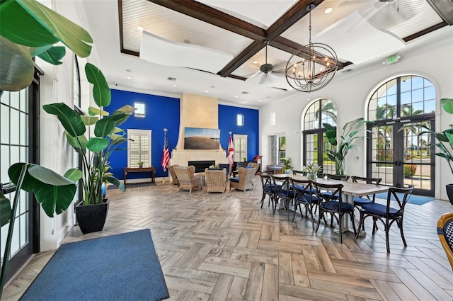 common area featuring a towering ceiling, coffered ceiling, recessed lighting, and beamed ceiling