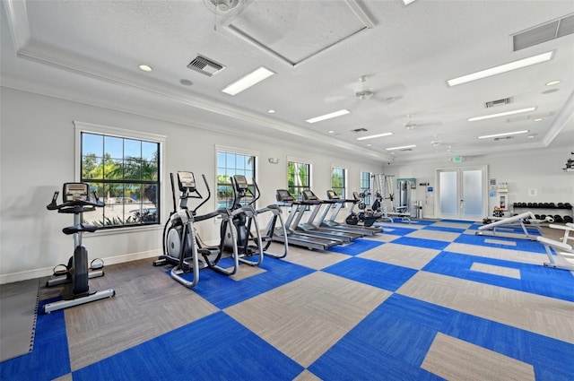 exercise room with carpet flooring, ornamental molding, a raised ceiling, baseboards, and a textured ceiling