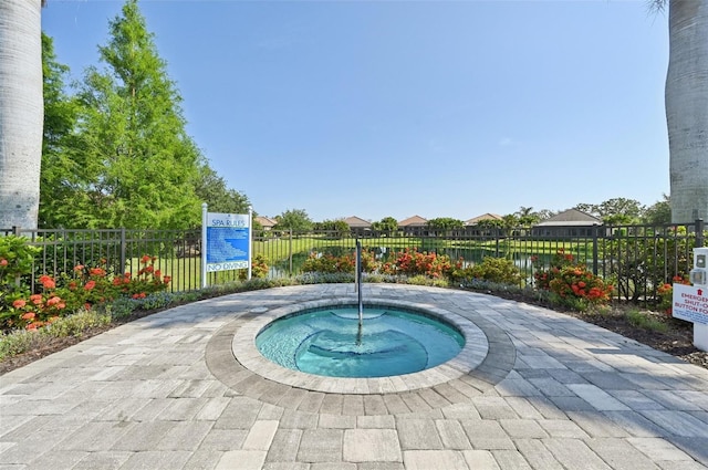view of swimming pool featuring a hot tub and fence
