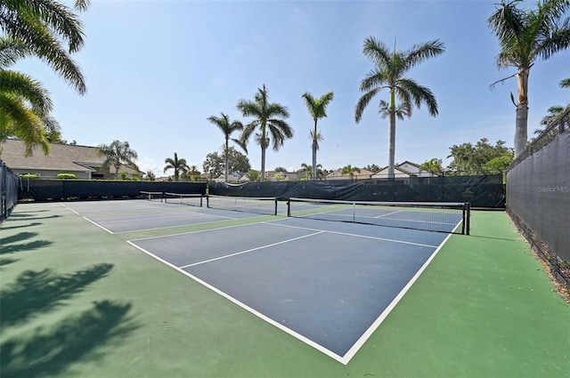 view of tennis court with community basketball court and fence