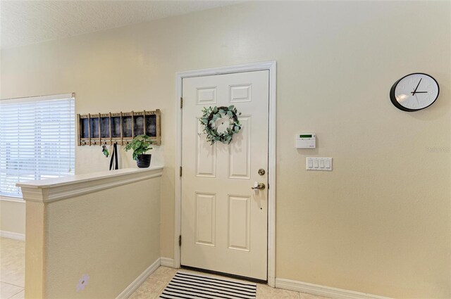 entrance foyer with baseboards and light tile patterned floors