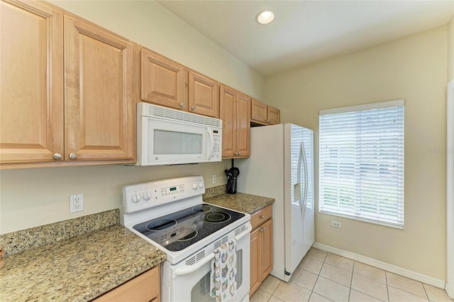 kitchen with baseboards, light stone counters, light tile patterned flooring, recessed lighting, and white appliances