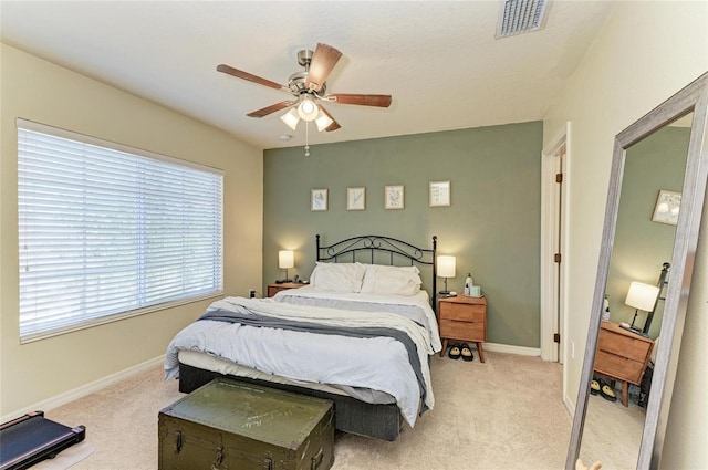 bedroom with baseboards, light colored carpet, and visible vents