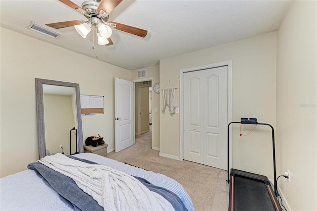bedroom featuring ceiling fan, light carpet, baseboards, visible vents, and a closet