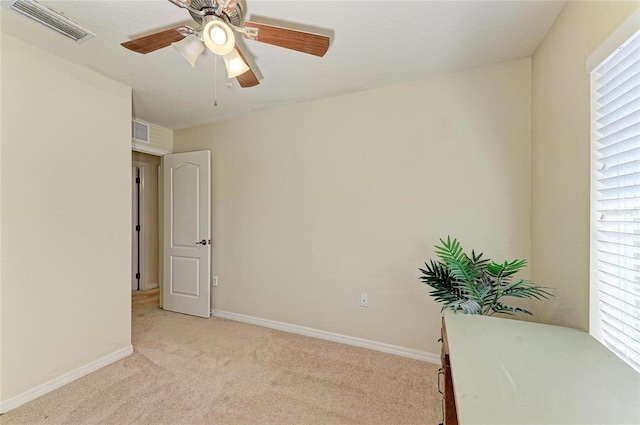 unfurnished room featuring baseboards, light carpet, a ceiling fan, and visible vents