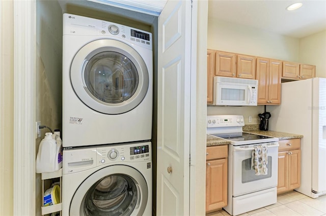 washroom with light tile patterned floors, laundry area, and stacked washer / dryer