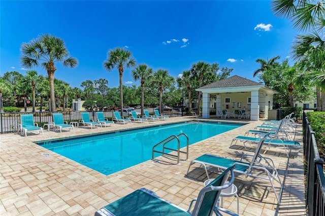 community pool with fence and a patio area