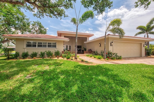 view of front of home featuring a front yard, stucco siding, and a garage