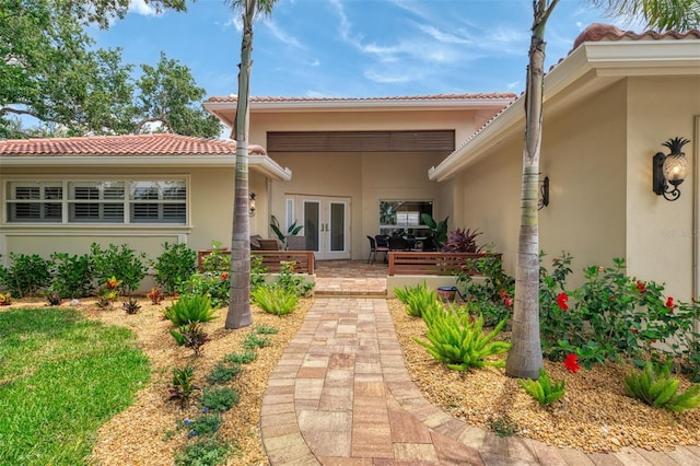 exterior space with a patio area, stucco siding, french doors, and a tiled roof