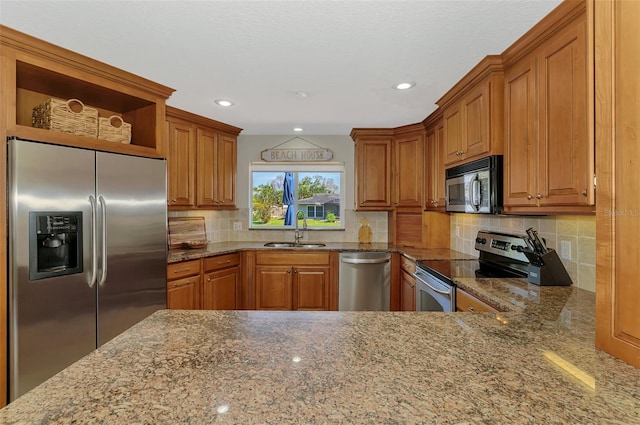 kitchen featuring a sink, stone countertops, brown cabinetry, stainless steel appliances, and open shelves