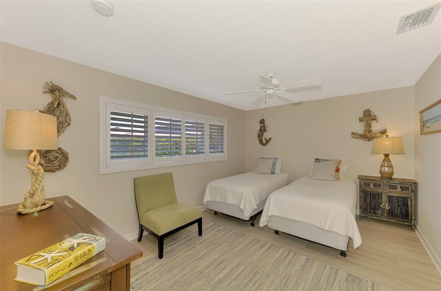 bedroom featuring light wood finished floors, baseboards, ceiling fan, and visible vents