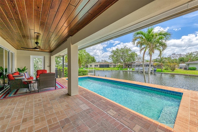 outdoor pool featuring a patio area and a water view