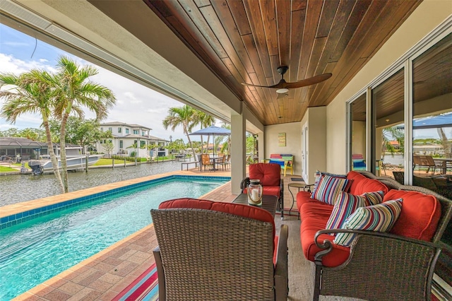 pool featuring an outdoor hangout area, a patio, a water view, and ceiling fan