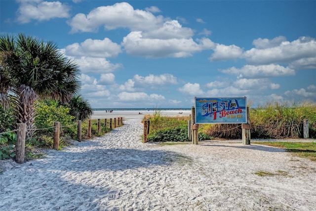 view of property's community with a beach view and a water view