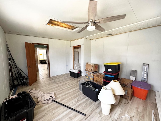 interior space with attic access, a ceiling fan, and wood finished floors
