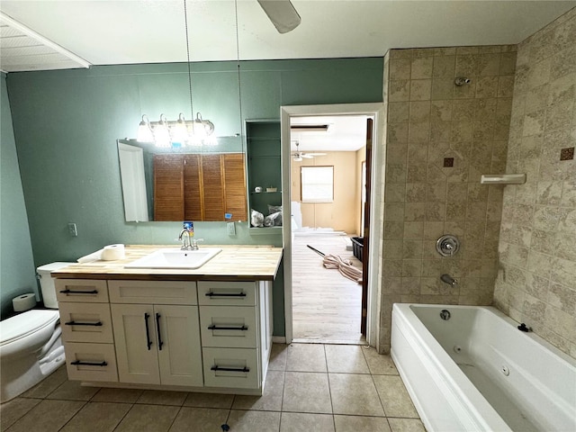 bathroom with a combined bath / shower with jetted tub, toilet, a ceiling fan, tile patterned floors, and vanity