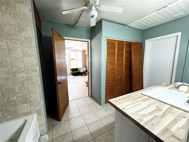 bathroom with vanity, ceiling fan, a bathtub, and tile patterned floors