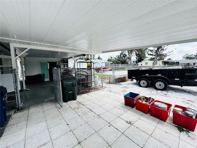 view of patio featuring a gate, fence, and a carport