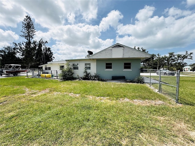 back of house with a lawn and fence
