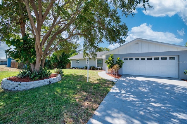 ranch-style home featuring a garage, concrete driveway, and a front yard