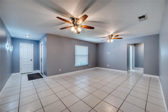 unfurnished room featuring visible vents, a ceiling fan, and light tile patterned floors