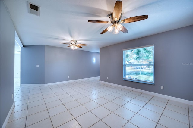 empty room featuring light tile patterned floors, baseboards, ceiling fan, and visible vents