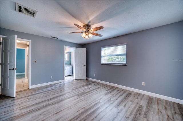 unfurnished bedroom featuring baseboards, visible vents, and light wood-style floors