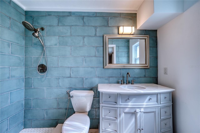 bathroom featuring vanity, a tile shower, and toilet