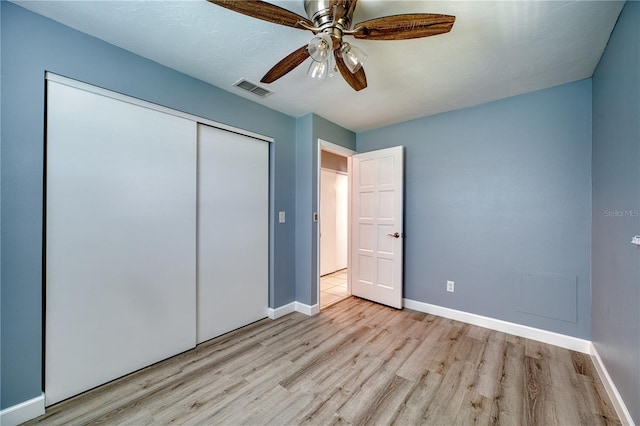 unfurnished bedroom with baseboards, visible vents, light wood-style flooring, and a closet