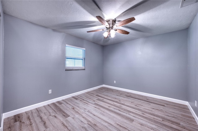 empty room with visible vents, wood finished floors, baseboards, a textured ceiling, and a ceiling fan