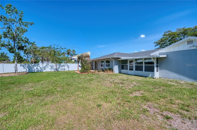 view of yard with fence and a sunroom