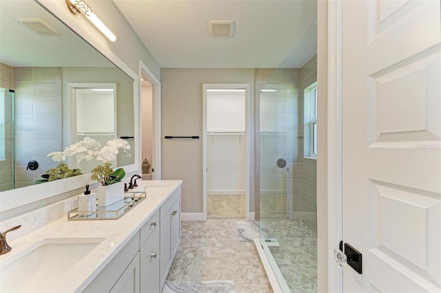 bathroom with visible vents, a sink, and a shower stall