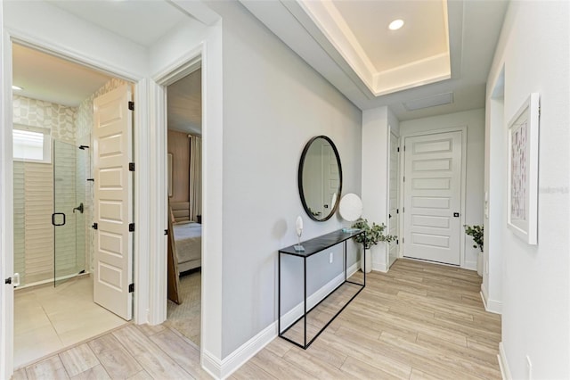hallway featuring baseboards, recessed lighting, and light wood-style flooring