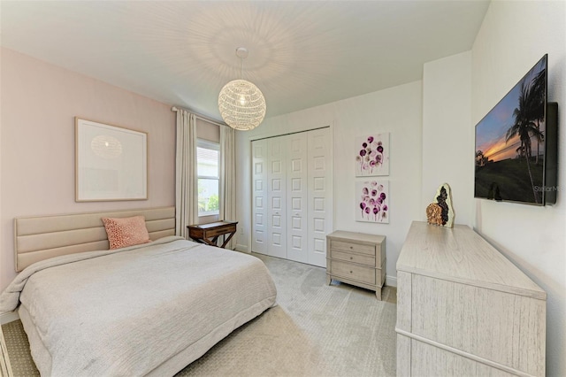 bedroom with baseboards, light carpet, a closet, and a chandelier