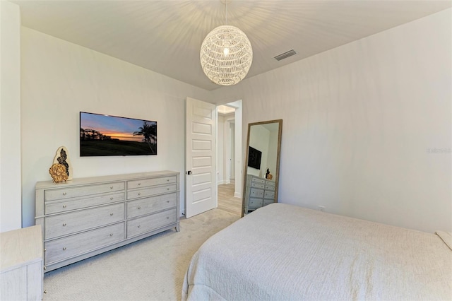 bedroom with visible vents, light carpet, and a notable chandelier