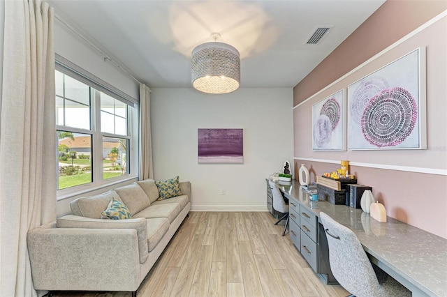 home office featuring a chandelier, baseboards, visible vents, and light wood-type flooring