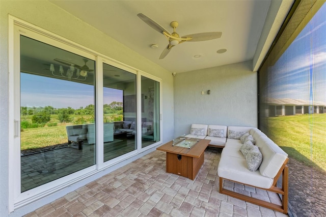 sunroom with ceiling fan and an outdoor living space with a fire pit