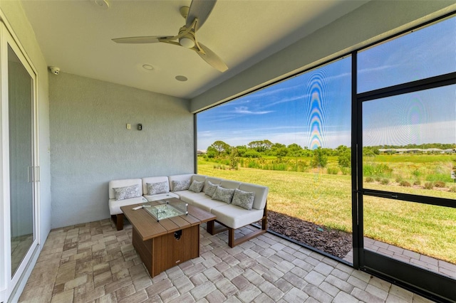 sunroom featuring a ceiling fan and an outdoor hangout area