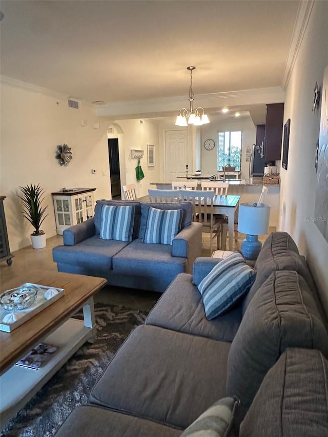 living area with crown molding, a chandelier, and visible vents