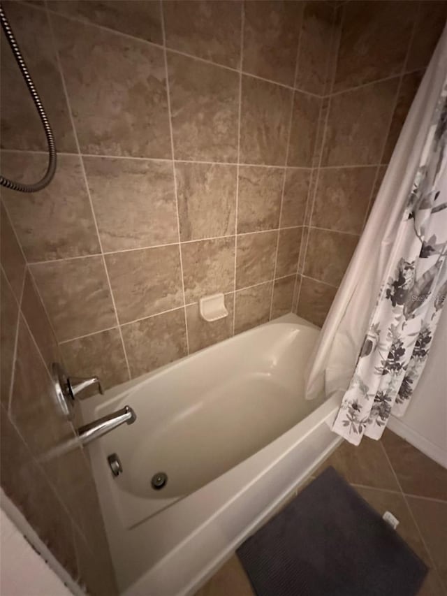 full bath featuring tile patterned floors and shower / bath combo with shower curtain