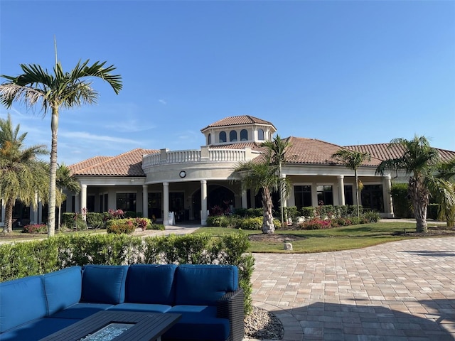 back of property featuring outdoor lounge area, a tile roof, and stucco siding