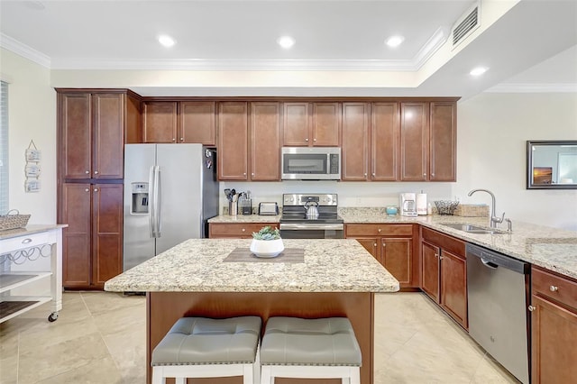 17118 Vardon Ter Unit 304, Bradenton, FL 34211 - kitchen with appliances with stainless steel finishes, a sink, ornamental molding, light stone countertops, and a kitchen breakfast bar