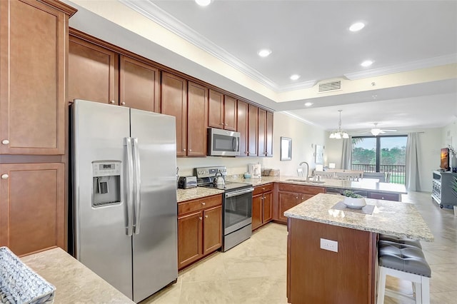17118 Vardon Ter Unit 304, Bradenton, FL 34211 - kitchen with appliances with stainless steel finishes, a sink, ornamental molding, a peninsula, and a breakfast bar