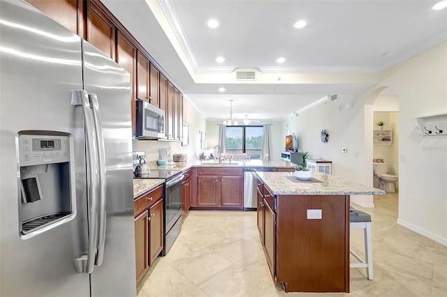 17118 Vardon Ter Unit 304, Bradenton, FL 34211 - kitchen with appliances with stainless steel finishes, crown molding, a sink, a peninsula, and a kitchen bar