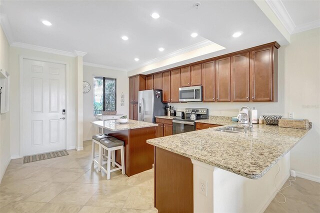 17118 Vardon Ter Unit 304, Bradenton, FL 34211 - kitchen featuring stainless steel appliances, a breakfast bar, a sink, crown molding, and a kitchen island