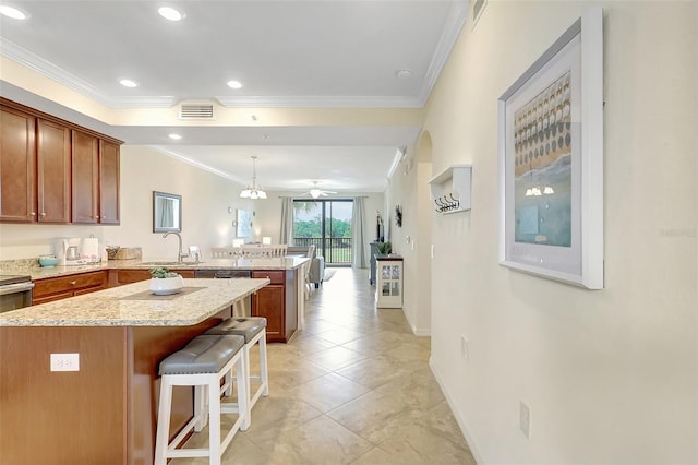 17118 Vardon Ter Unit 304, Bradenton, FL 34211 - kitchen featuring a peninsula, crown molding, a sink, a kitchen bar, and baseboards
