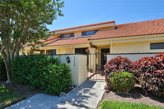 5362 Huntingwood Ct Unit 16, Sarasota, FL 34235 - mediterranean / spanish house with a tile roof, fence, a gate, and stucco siding